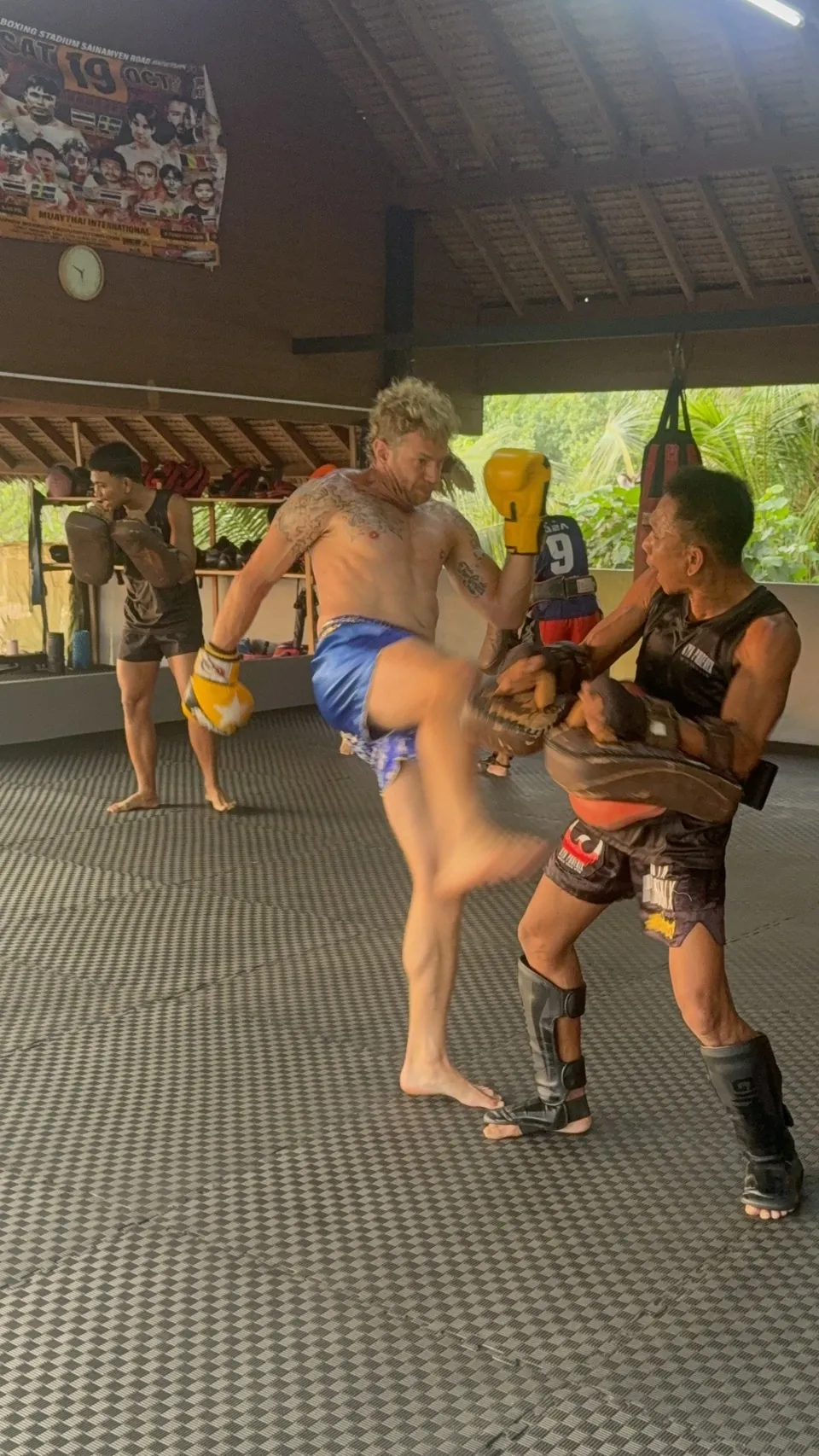 Student kicking pads held by a trainer
