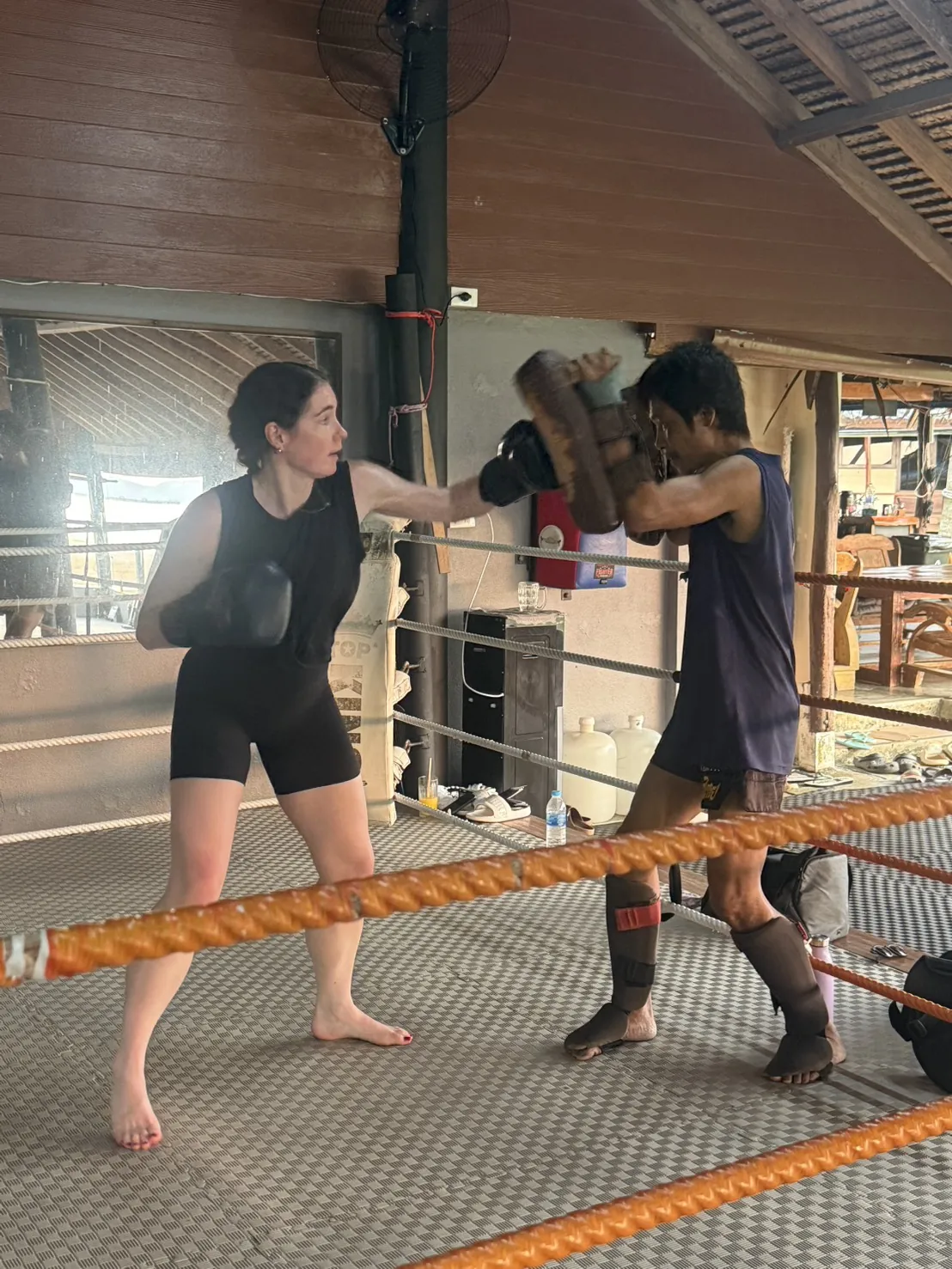 Pad work with a trainer by the ring