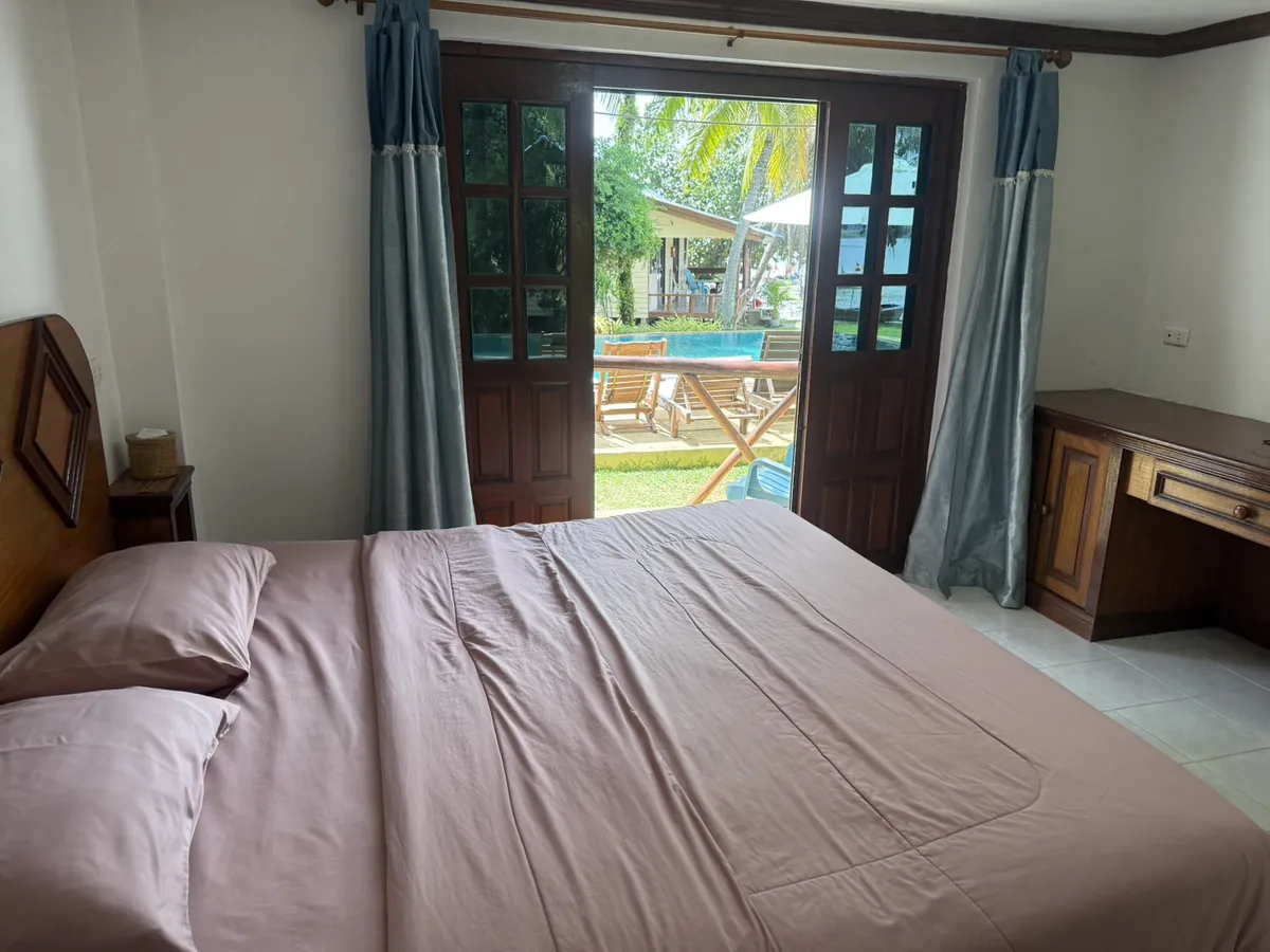 AC deluxe room with doors opening onto the pool garden