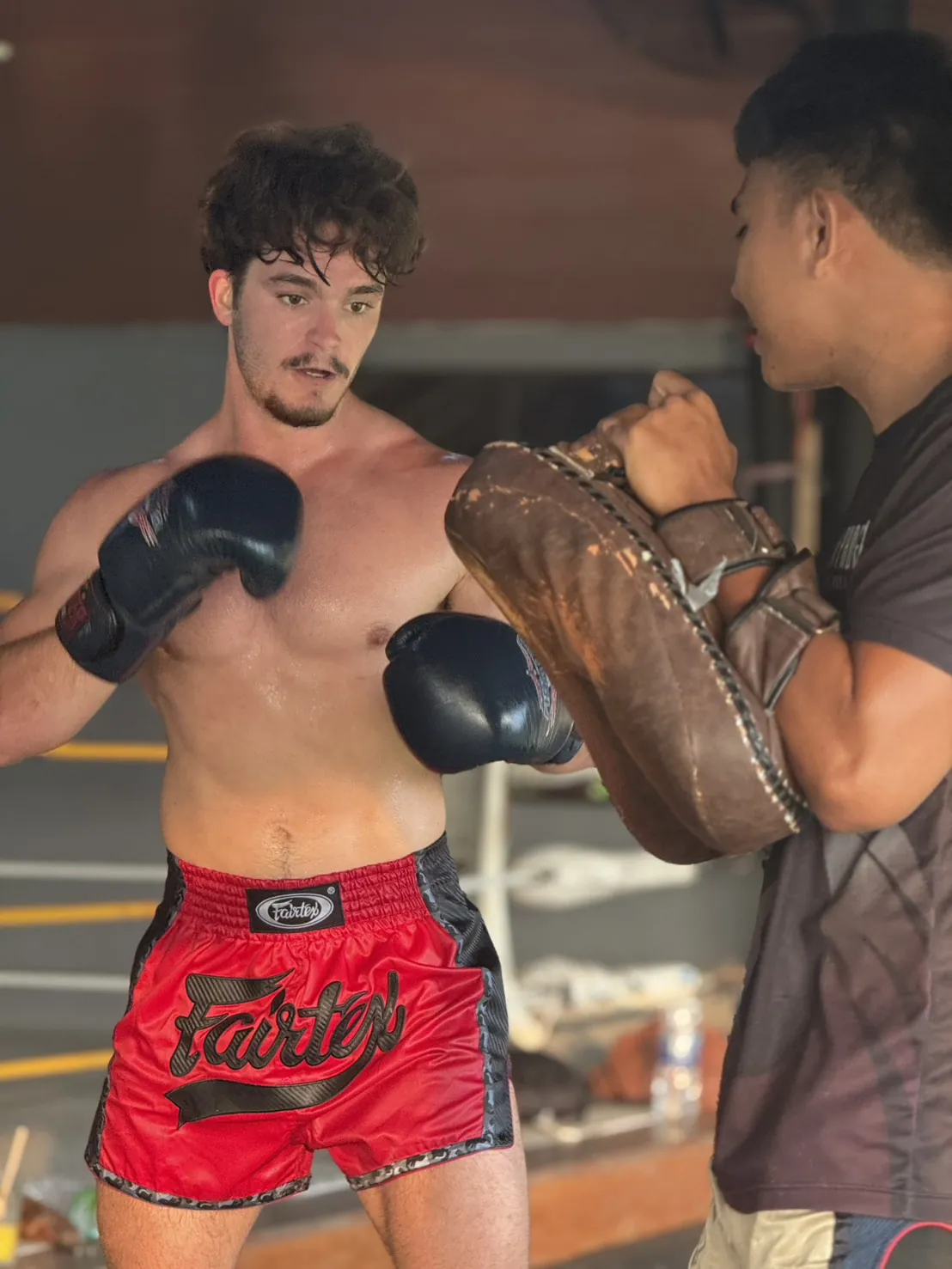 Student learning Muay Thai on the pads with a KYN Phoenix trainer